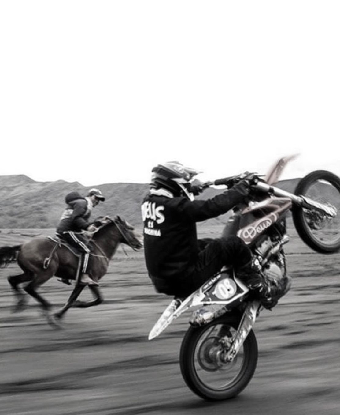 Motorista haciendo un caballito en una escena en blanco y negro